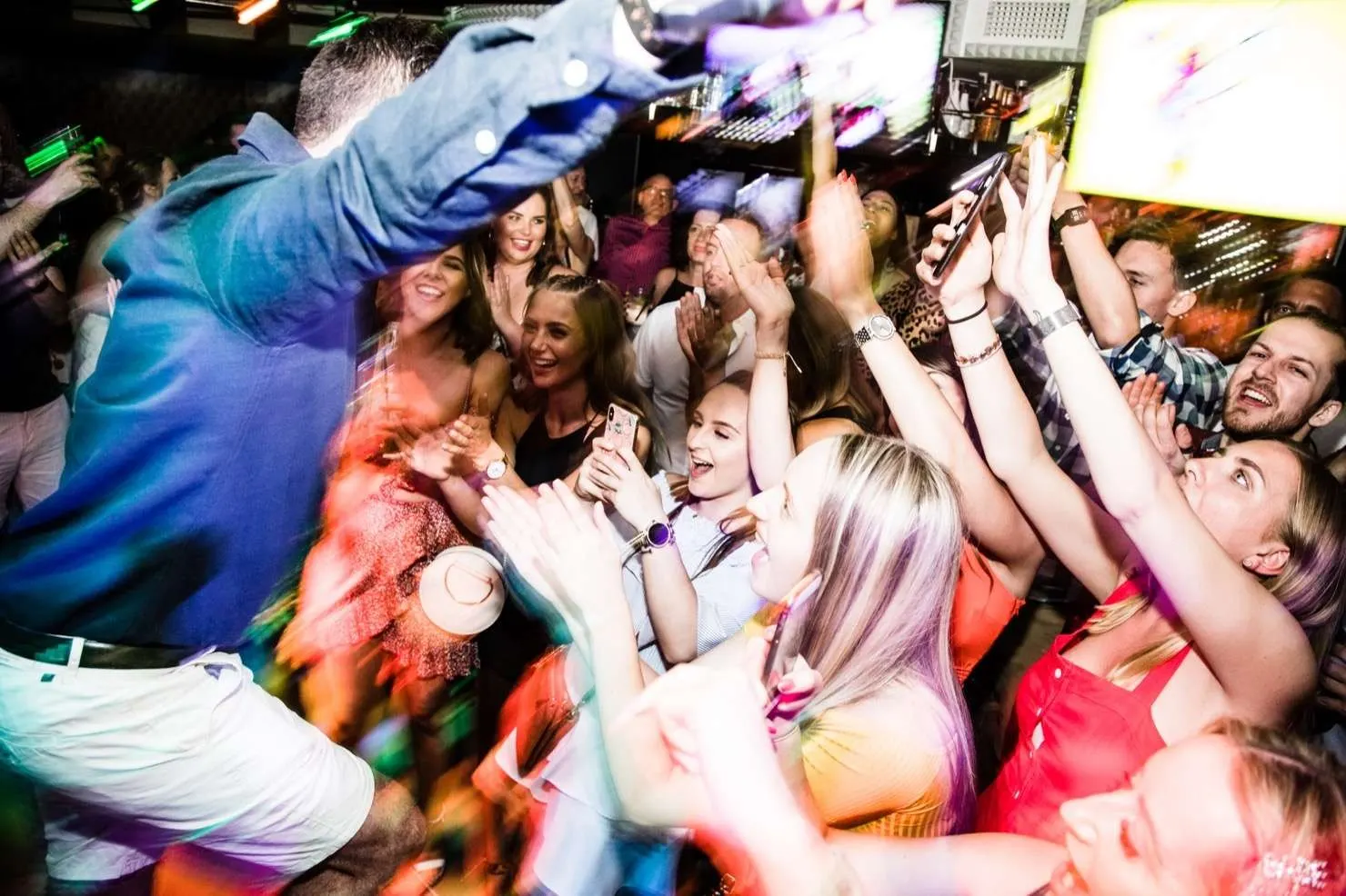 A packed crowd with hands in the air