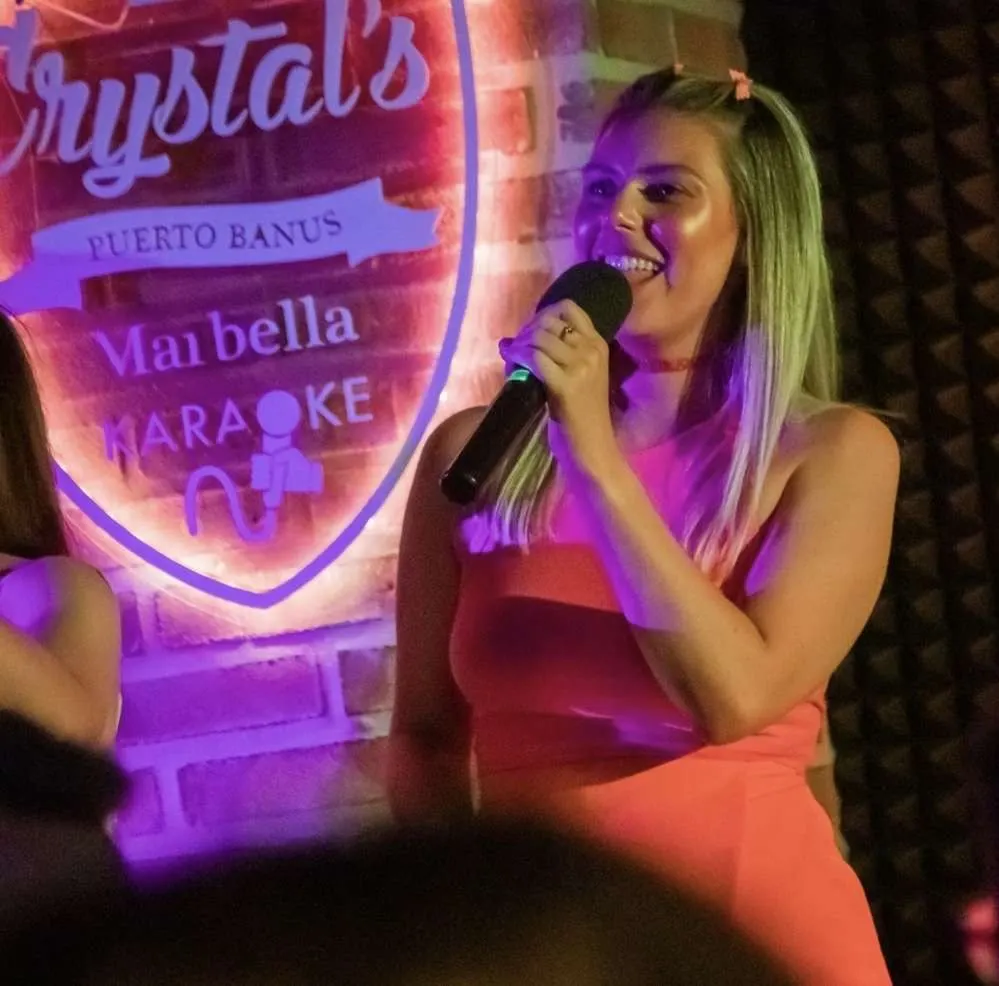 A singer performs in front of the Crystal’s neon shield